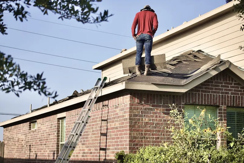 Professional roofer working on a residential roof in Moe